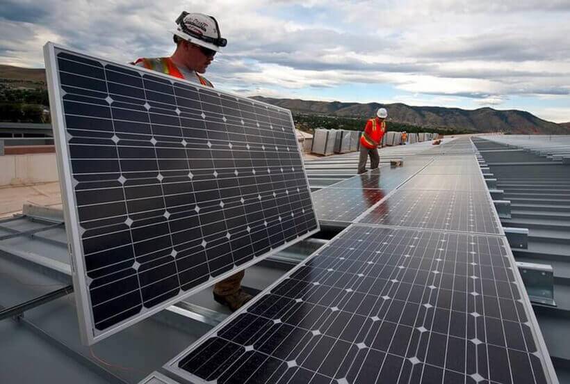 men installing solar panels on a new roof