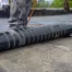 A professional roofer rolls out a black roof cover, showcasing techniques for flat roof repair