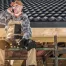 A professional roofer sits atop a roof, representing Guardian Roofing's role in increasing home value in Houston with new roofing installation